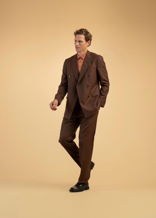 Dunkelbrauner Anzug mit oranger Polo-Kombination Dunkelbrauner Doppelreiher-Anzug kombiniert mit oranger Poloshirt – moderner Business-Look mit sportlicher Note.