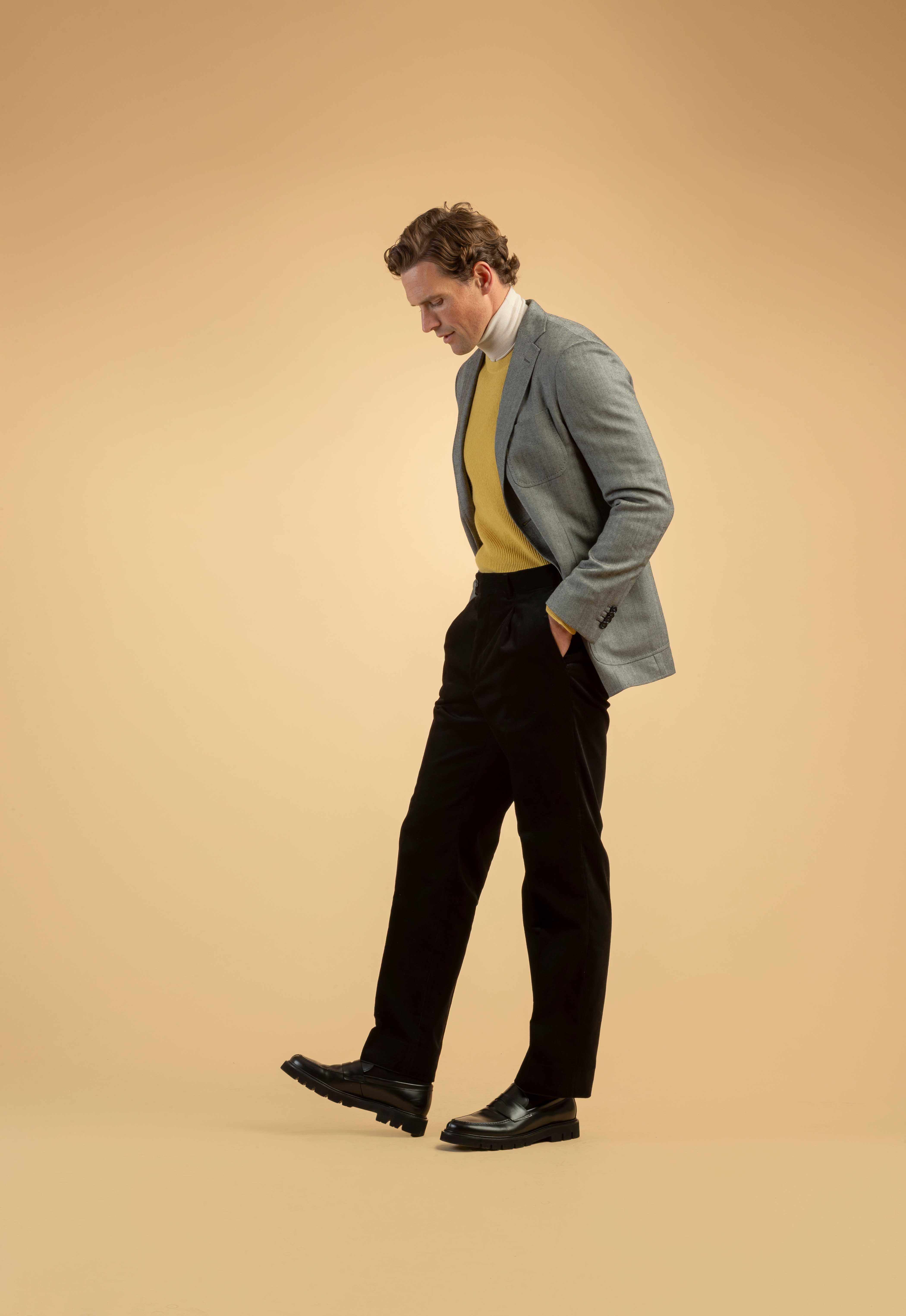 Herren-Outfit mit grauem Blazer, gelbem Pullover und schwarzer Hose – modern und elegant Grauer Blazer mit gelbem Pullover und schwarzer Hose – stilvoller Herren-Look in smart-casual Kombination.