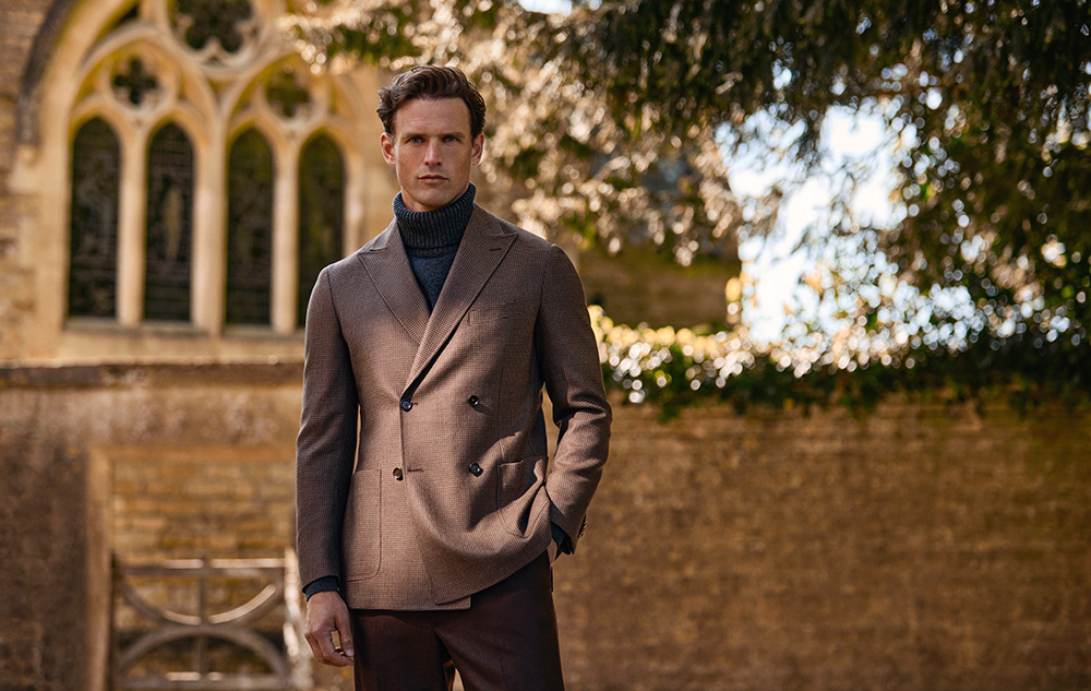 Herbstlicher Herrenlook mit braunem Sakko und Rollkragenpullover im Freien Mann in braunem Doppelreiher-Sakko mit dunkelblauem Rollkragenpullover vor historischer Kulisse im Freien.