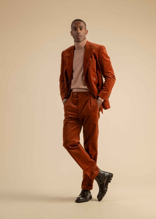 Rostbrauner Cordanzug mit Rollkragenpullover – moderner Retro-Look für Herren Herrenanzug aus rostbraunem Cord mit doppelreihigem Sakko, kombiniert mit beigem Rollkragenpullover und schwarzen Chelsea Boots.