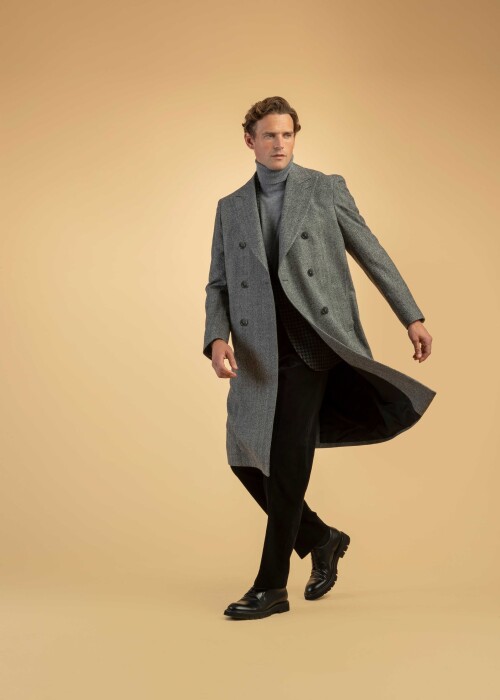 Herrenmode mit grauem Zweireiher-Mantel, Rollkragen und dunkler Hose – eleganter Winterlook in Bewegung