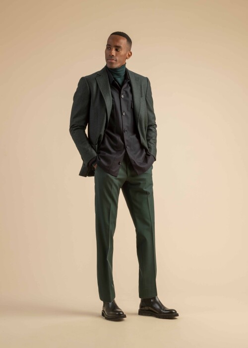 Eleganter Layering-Look mit grünem Anzug und Weste für den modernen Mann Grüner Herrenanzug mit dunklem Hemd, Weste und Rollkragenpullover – stilvoller Layering-Look für Herbst und Winter.