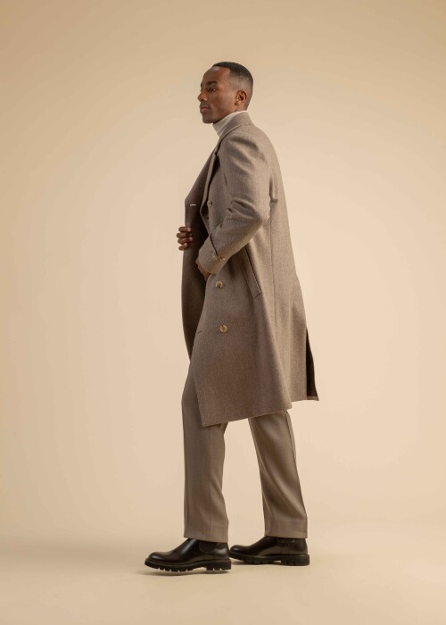 Eleganter Herren-Winterlook mit beigem Wollmantel, Rollkragenpullover und passender Hose – stilvoller Auftritt in monochromen Naturtönen.