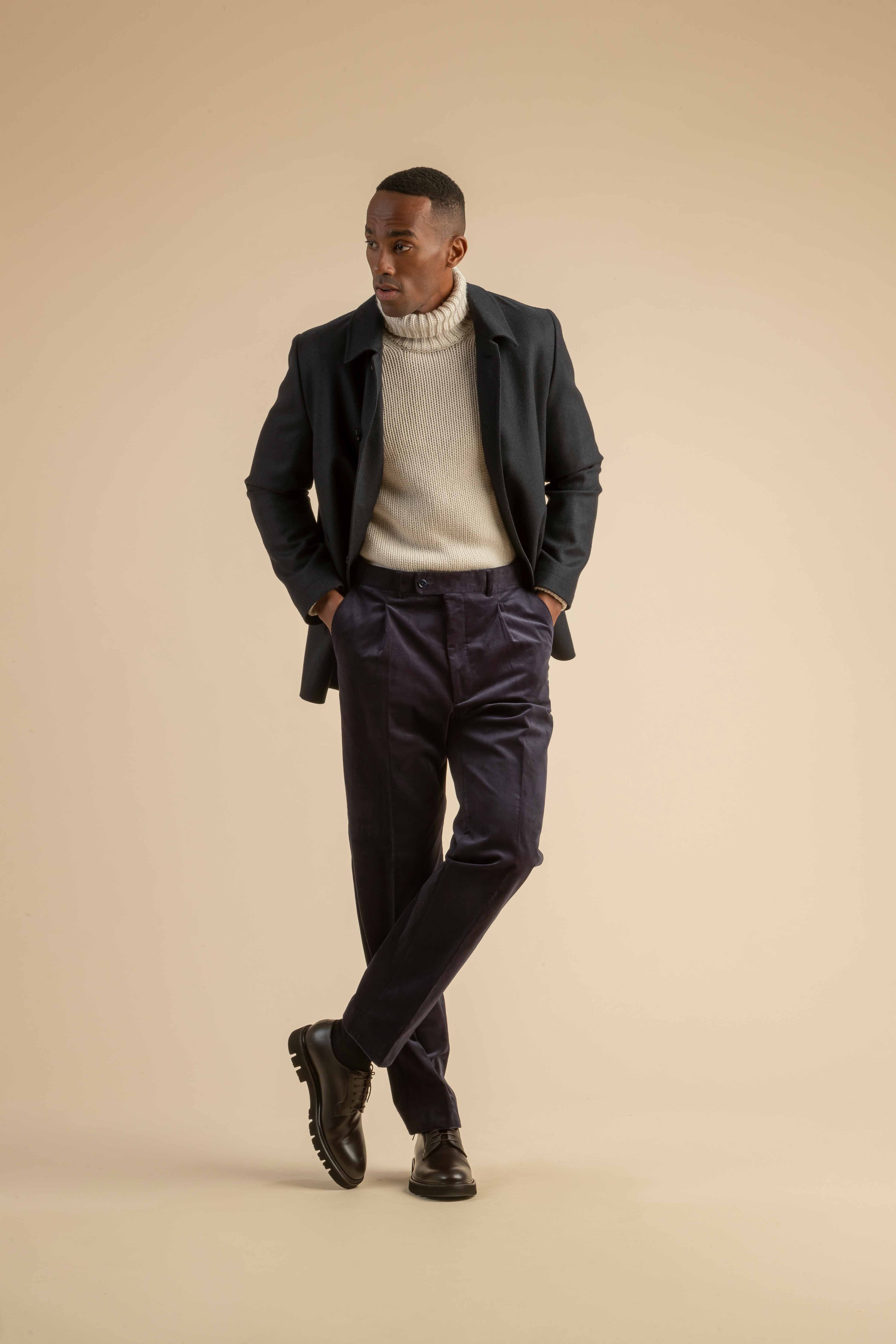 Herren-Winteroutfit mit Rollkragenpullover und Cordhose Herren-Outfit mit dunkelblauem Mantel, grobem Rollkragenpullover und violetter Cordhose – stilvoller Winterlook mit Struktur und Kontrast.