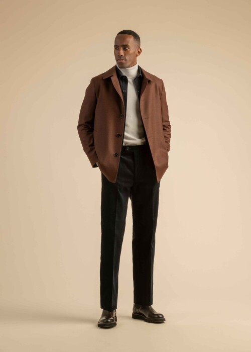 Modernes Herren-Winteroutfit mit braunem Mantel, hellem Rollkragenpullover, Hemdjacke und dunkler Cordhose – stilvoll und alltagstauglich.