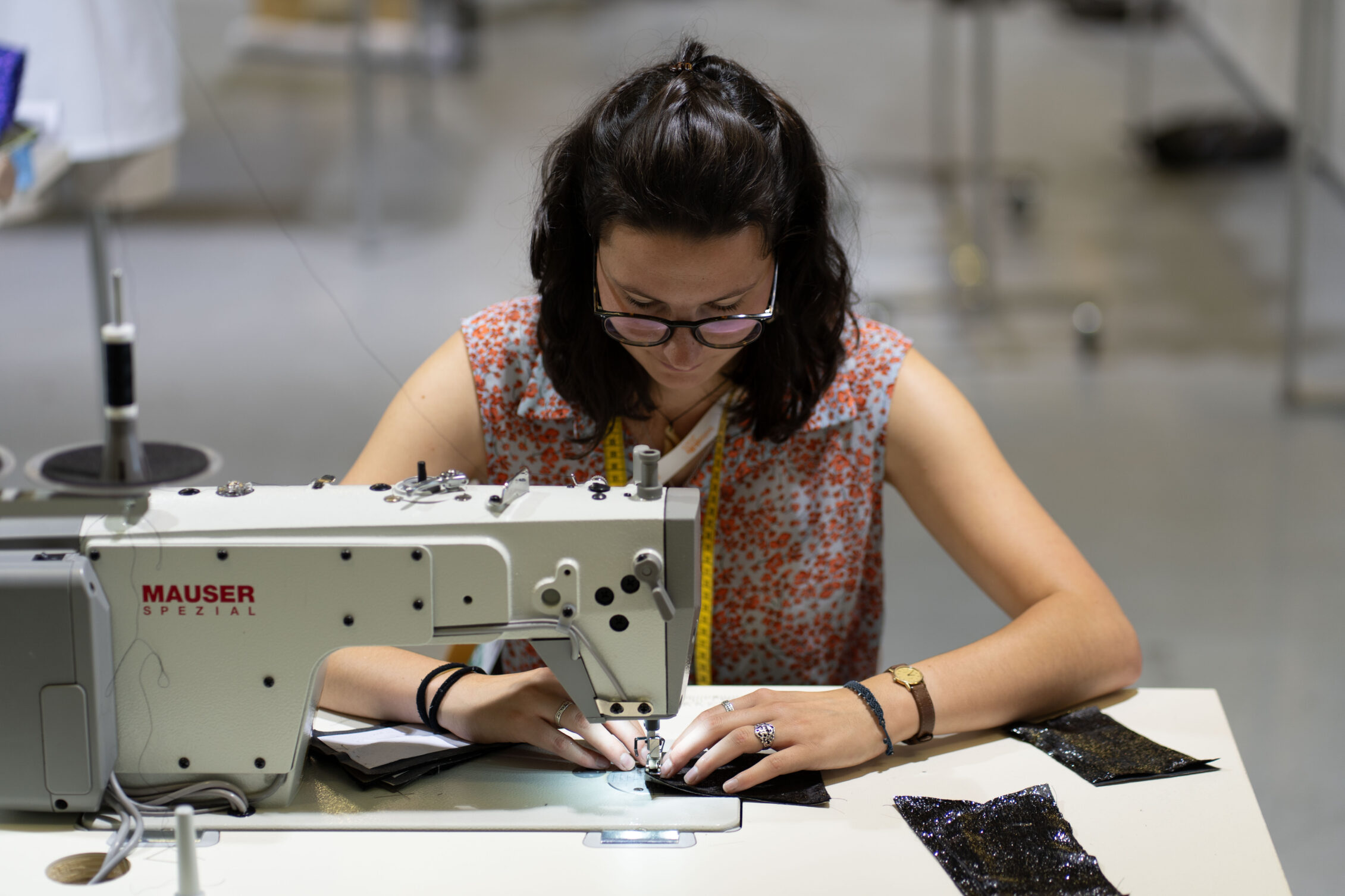 Lernende Bekleidungsgestalterin arbeitet an der Nähmaschine im Wettkampfbereich der SwissSkills 2025 in Bern.