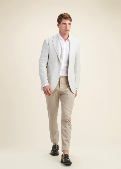 Sommerlicher Herrenlook aus der Scabal Frühling Sommer 2026 Kollektion mit cremefarbenem Sakko aus der Jazz Kollektion, kombiniert mit beiger Hose.
