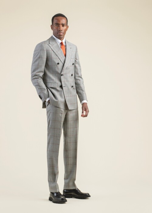 Eleganter Scabal Anzug mit Fensterkaro aus der scabal frühling sommer 2026 Kollektion, getragen von einem Model mit oranger Krawatte und weissem Hemd.