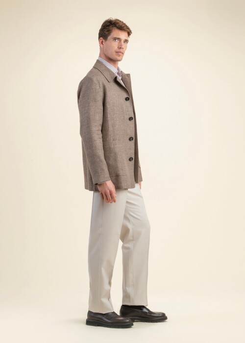Eleganter Herrenmantel aus der Scabal Frühling Sommer 2026 Kollektion in Beige, kombiniert mit heller Hose – stilvoller Look auf Mass aus St.Gallen.