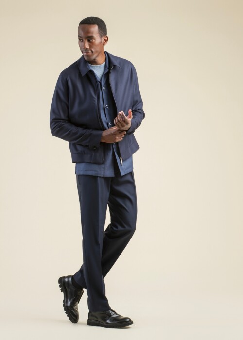 Herrenlook aus der Scabal Frühling Sommer 2026 Kollektion mit dunkelblauer Warwick 6 Bomberjacke, Plymouth 1 Overshirt und eleganter Hose aus der Image Linie.