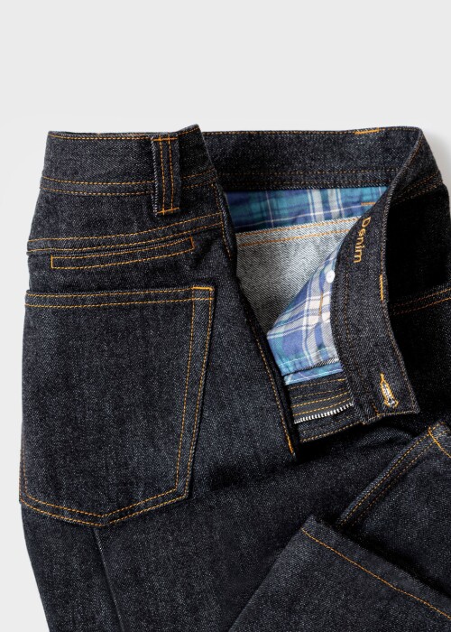 Detailaufnahme der Borelio Jeanshose aus dunklem Denim mit geöffneter Front und kariertem Innenfutter