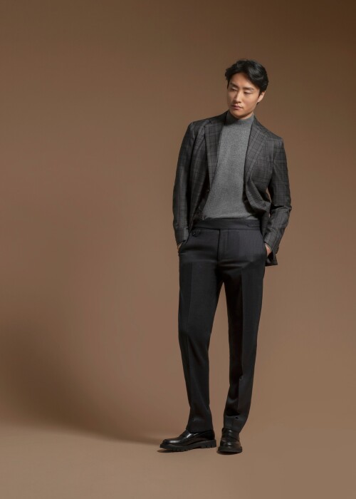 Scabal Anzug mit dunkel kariertem Sakko und grauem Rollkragenpullover aus der Herbst-Winterkollektion 2026, individuell massgeschneidert von Die Manufaktur – deine Schneiderei in St. Gallen.