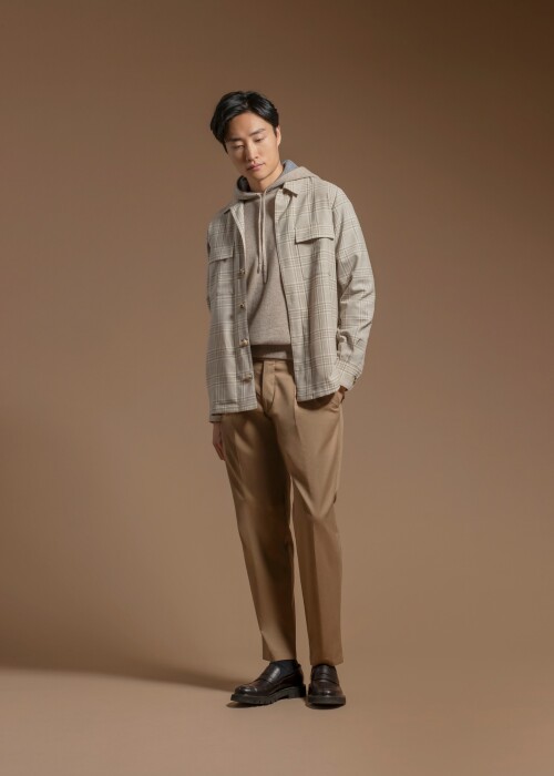 Moderner Casual Look mit kariertem Overshirt, beigem Hoodie und camelfarbener Hose aus der Herbst-Winterkollektion 2026, individuell massgeschneidert von Die Manufaktur – deine Schneiderei in St. Gallen.